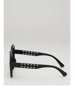 Détails de lunettes de soleil noires avec branches géométriques ajourées et accents dorés