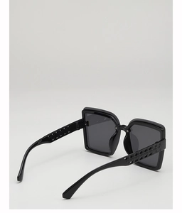 Détail de lunettes de soleil noires carrées avec motifs géométriques sur les branches