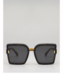 Détail de lunettes de soleil carrées écaillées avec verres gris et détails dorés
