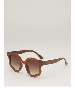 Detail shot of brown wavy frame sunglasses featuring stylish gradient lenses on white backdrop