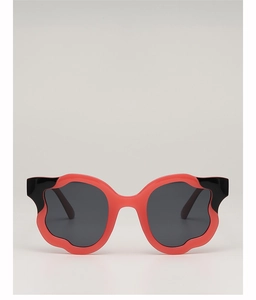 Close-up of wavy irregular coral red sunglasses frame with black contrast temples
