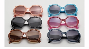 Flat lay of oversized wavy geometric sunglasses in six vibrant fashion colors