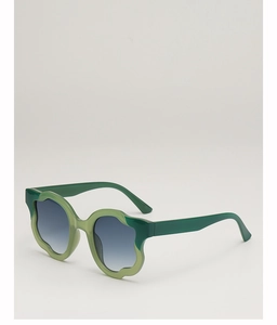 Detail of irregular wave-edged sunglasses with green patchwork frames and gradient lenses