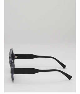 Detail view of large purple sunglasses featuring a black wide temple and metal hinge