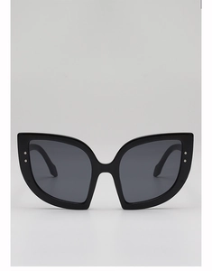 Dettaglio di occhiali da sole cat-eye neri con borchie argentate e lenti grigio scuro