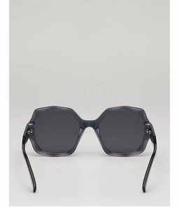 Detail view of large dark grey translucent sunglasses with geometric polygon frames