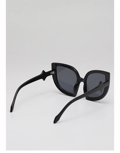 Dettaglio degli occhiali da sole cat-eye neri con accenti metallici a stella sulle aste