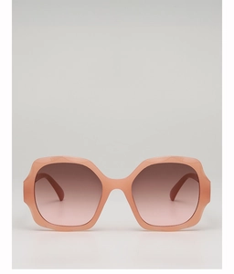 Detailed view of oversized hexagonal sunglasses with nude pink frames and gradient lenses