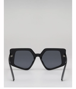 Macro detail of geometric oversized sunglasses featuring black square frames and dark lenses