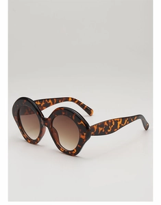 Close-up of vintage cat-eye sunglasses featuring oversized tortoiseshell leopard frames