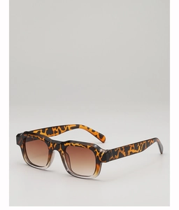 Detail of square tortoiseshell sunglasses with brown gradient lenses and thick resin frame