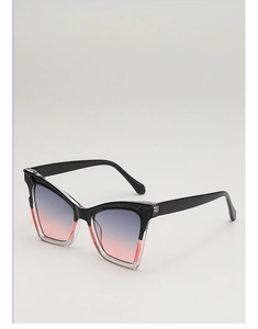 Close-up of cat-eye sunglasses with black and transparent frames and gradient lenses