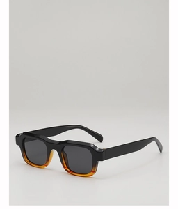 Detail view of bold square sunglasses featuring a black and amber tortoiseshell gradient frame