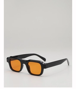 Detail of square sunglasses with a glossy black frame and vibrant orange lenses