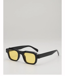 Macro shot of retro square sunglasses with thick black frame and yellow amber lenses