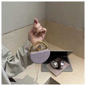 Detail of lavender rhinestone dinner bag with gold ring handle and pearl decor