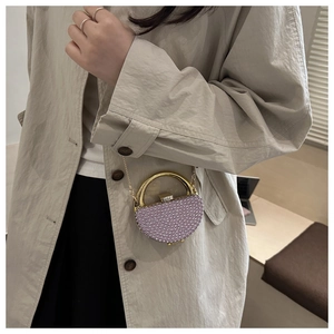 Detail of a purple beaded mini evening bag with gold circular handle and crystal clasp
