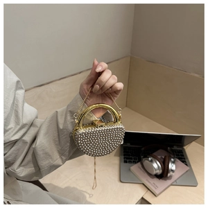 Detail of evening clutch bag with rhinestones, gold handle and metal chain strap