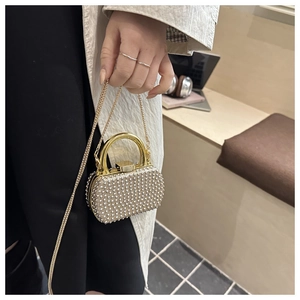 Detail view of the beaded rhinestone evening bag with a gold handle and chain strap