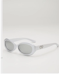 Détail de lunettes de soleil ovales argentées style Y2K avec découpes de double cœur