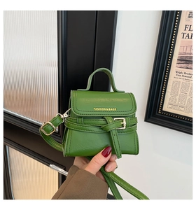 Dettaglio della pelle verde lime e scritte dorate sulla borsa a mano alla moda