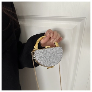 Detail of evening clutch with silver rhinestones, gold handle and detachable chain strap