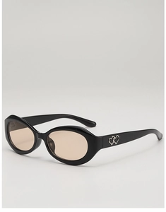 Détail de lunettes de soleil ovales avec décoration double cœur en métal et verres teintés
