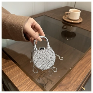 Close-up of sparkling silver rhinestone evening bag with elegant metal handle and chain