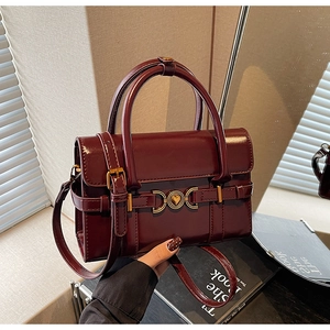 Vue détaillée du sac à main rouge foncé avec une boucle cœur dorée et texture élégante