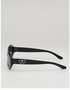 Détail de lunettes de soleil ovales noires tendance avec double cœurs argentés latéraux