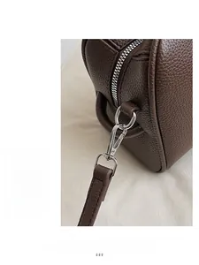 Détail du cuir grainé marron foncé avec fermeture éclair argentée et crochet métallique