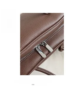 Détails de double fermeture éclair argentée sur sac en cuir grainé marron foncé élégant