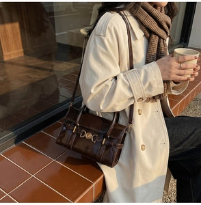 Détail du sac vintage en cuir marron brillant avec boucle en métal doré élégante
