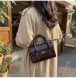 Photo en extérieur d'un sac bandoulière vintage en cuir marron avec fermoir cœur