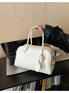 Gros plan du sac Boston en cuir blanc à motif lychee avec détail de poignée nouée