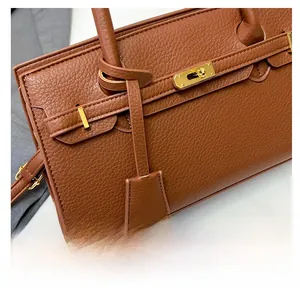 Détail du sac en cuir marron motif litchi avec fermoir rotatif en métal doré chic