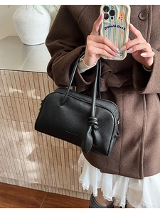 Vue détaillée d'un sac à main en cuir grainé noir avec un design de sangle nouée unique