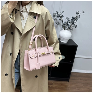 Detail of pink lychee texture leather bag with gold hardware and top handle strap