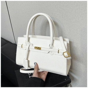 Detail of white lychee grain leather handbag with gold metal clasp and top handle