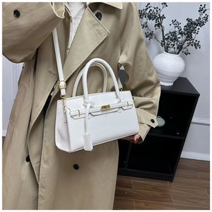 Detailed close-up of a white lychee grain leather handbag with gold twist-lock hardware