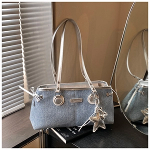 Macro view of blue denim fabric with silver metallic straps and a star pendant