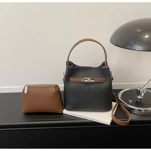 Ensemble sac seau et mini pochette motif litchi avec boucle argentée sur bureau moderne
