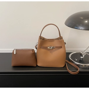 Détail de l'ensemble sac seau en cuir caramel avec texture litchi et boucle métallique