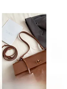 Detail of brown leather shoulder bag featuring vintage gold twist lock and adjustable strap
