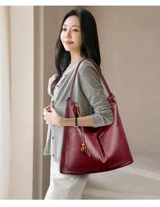 Détails du sac cabas en cuir bordeaux avec poches et accessoire pompon en perles