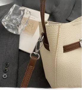 Détail du crochet en métal argenté sur sac à main en cuir grainé blanc cassé