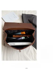 Detail view of large capacity brown leather bag with three organized compartments and zipper
