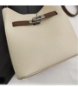 Détail du sac à main en cuir grainé avec sangle marron et fermoir rotatif argenté