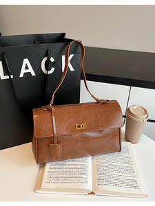 Close-up of vintage brown large capacity shoulder bag with gold metal twist lock detail