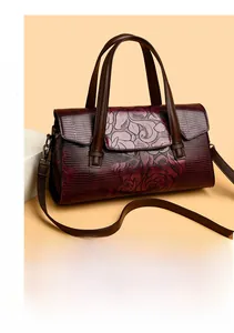 Dettaglio macro della borsa bordeaux con goffratura floreale e texture lucertola su pelle